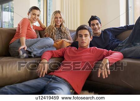 Stock Photo - Four teenage friends watching television. Fotosearch