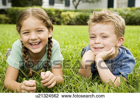 girl and boy smiling lying on the grass View Large Photo Image Stock Image - girl and boy smiling lying on the grass. Fotosearch