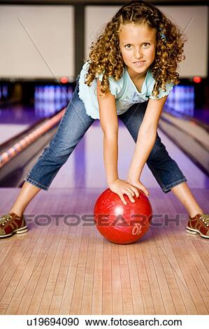 Girl in a bowling alley holding a red bowling ball View Large Photo Image Stock Image - Girl in a bowling alley holding a red bowling ball. Fotosearch