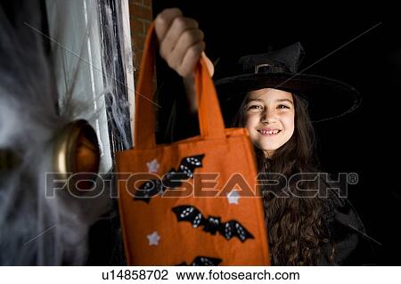 Girl in costume at a Hallowe'en party, holding an orange party bag View Large Photo Image Stock Image - Girl in costume at a Hallowe'en party, holding an orange party bag. Fotosearch