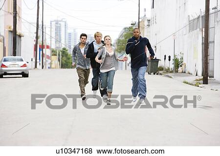 Group of teenagers running down an urban street View Large Photo Image Stock Photo - Group of teenagers running down an urban street . Fotosearch