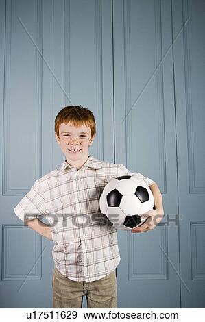 Stock Photo - happy little boy holding football. Fotosearch