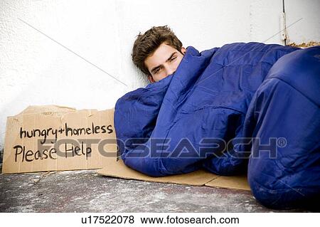 Homeless young man laying in the street View Large Photo Image Stock Photo - Homeless young man laying in the street . Fotosearch