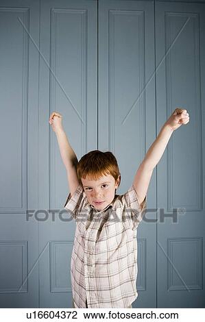 Stock Image - little boy arms raised in celebration. Fotosearch