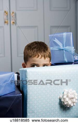 little boy hiding behind pile of presents View Large Photo Image Stock Photography - little boy hiding behind pile of presents. Fotosearch