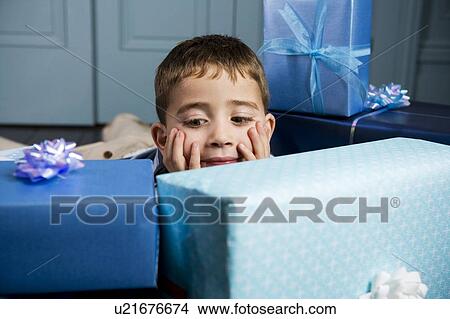 little boy looking at his presents View Large Photo Image Picture - little boy looking at his presents. Fotosearch