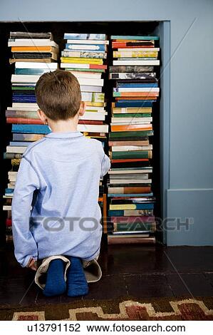 little boy looking for book in bookshelf View Large Photo Image Stock Image - little boy looking for book in bookshelf. Fotosearch