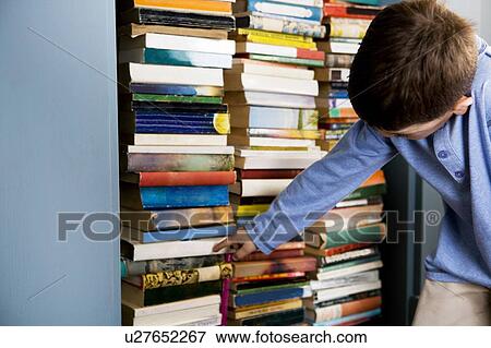 little boy looking for book in bookshelf View Large Photo Image Stock Photo - little boy looking for book in bookshelf. Fotosearch