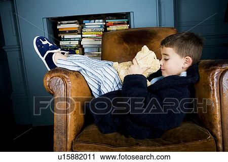 little boy lying in armchair with teddy bear View Large Photo Image Stock Image - little boy lying in armchair with teddy bear. Fotosearch