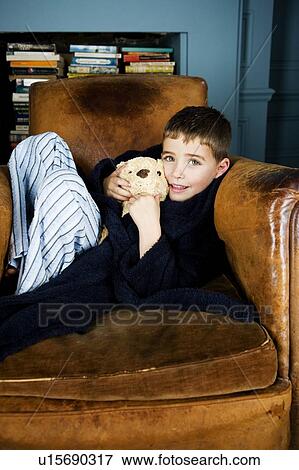 Little boy sitting in armchair with teddy bear View Large Photo Image Stock Photo - Little boy sitting in armchair with teddy bear. Fotosearch