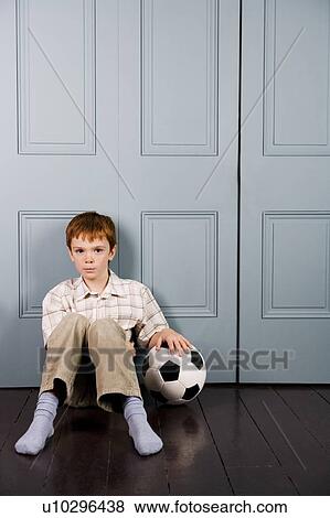 little boy sitting on floor with football View Large Photo Image Stock Photo - little boy sitting on floor with football. Fotosearch