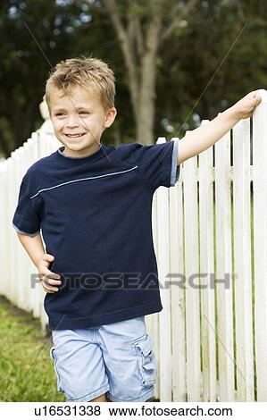 little boy standing by picket fence View Large Photo Image Stock Photo - little boy standing by picket fence. Fotosearch