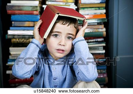 Stock Image - little boy with book on his head. Fotosearch
