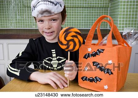 Stock Image - Little boy with trick or treat sweets. Fotosearch
