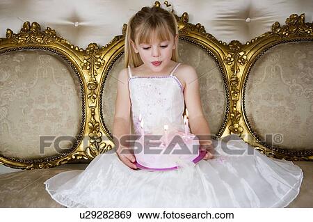 Little girl holding a birthday cake with lit candles View Large Photo Image Stock Photo - Little girl holding a birthday cake with lit candles. Fotosearch