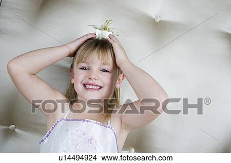 Little girl holding a present on top of her head View Large Photo Image Picture - Little girl holding a present on top of her head. Fotosearch