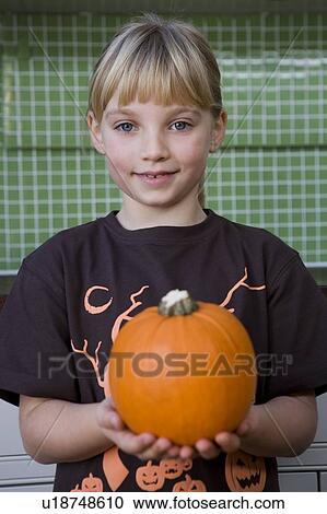 Little girl holding an orange Hallowe'en pumpkin View Large Photo Image Stock Image - Little girl holding an orange Hallowe'en pumpkin. Fotosearch