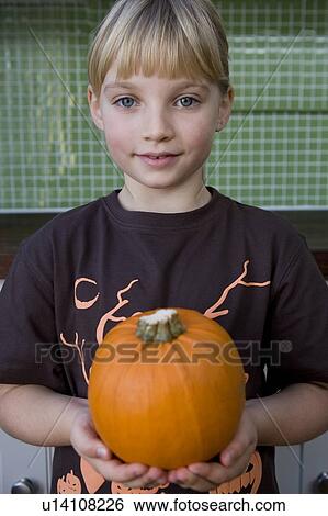 Stock Photograph - Little girl holding an orange Hallowe'en pumpkin. Fotosearch