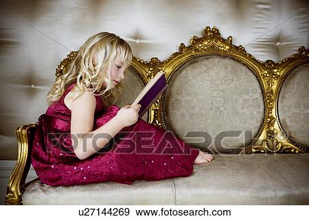 Stock Photo - Little girl in a party dress, reading a book. Fotosearch