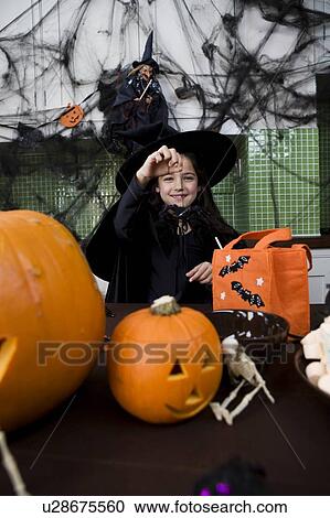 Stock Image - Little girl in a witch's outfit at a Halloween party . Fotosearch