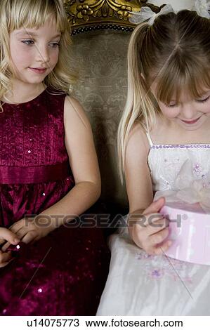 Stock Image - Little girls sharing birthday presents. Fotosearch