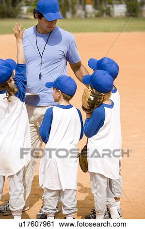 Stock Image - Little league baseball team and coach on pitch. Fotosearch