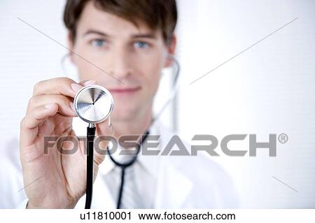 Male doctor holding a stethoscope towards the camera View Large Photo Image Stock Image - Male doctor holding a stethoscope towards the camera. Fotosearch
