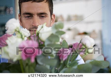 Stock Image - Male florist amongst the flowers in his shop. Fotosearch