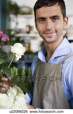 Stock Photograph - Male florist amongst the flowers in his shop. Fotosearch