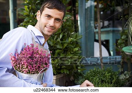 Male florist arranging the plant display outside his shop View Large Photo Image Picture - Male florist arranging the plant display outside his shop. Fotosearch