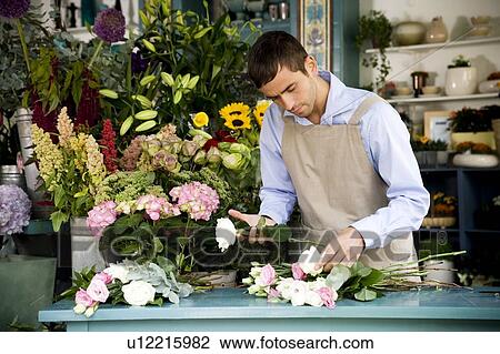 Stock Image - Male florist creating a bouquet of flowers. Fotosearch