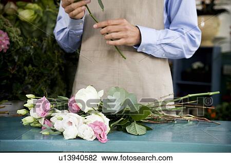 Stock Image - Male florist creating a bouquet of flowers. Fotosearch