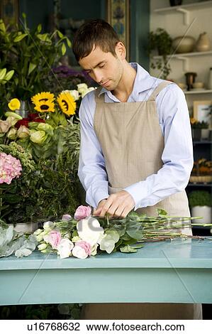 Stock Image - Male florist creating a bouquet of flowers. Fotosearch