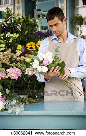 Stock Image - Male florist creating a bouquet of flowers. Fotosearch