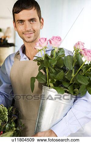 Male florist in his shop, holding a pot of pink roses View Large Photo Image Stock Photo - Male florist in his shop, holding a pot of pink roses. Fotosearch