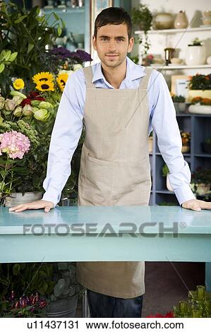 Male florist standing behind the counter in his shop View Large Photo Image Stock Image - Male florist standing behind the counter in his shop. Fotosearch