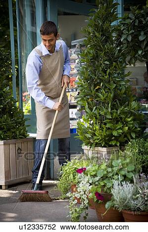 Male florist sweeping up outside his shop View Large Photo Image Stock Image - Male florist sweeping up outside his shop. Fotosearch