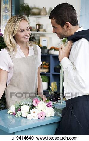 Man buying a bouquet of flowers in a florist's shop, flirting with the assistant View Large Photo Image Stock Image - Man buying a bouquet of flowers in a florist's shop, flirting with the assistant. Fotosearch