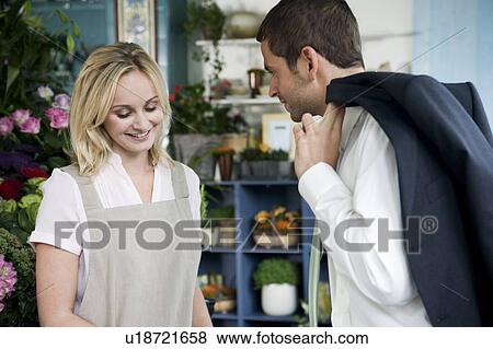 Stock Photo - Man buying a bouquet of flowers in a florist's shop, flirting with the assistant. Fotosearch