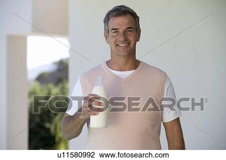 Man holding a bottle of milk View Large Photo Image Stock Image - Man holding a bottle of milk. Fotosearch