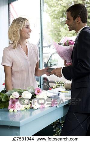 Man in a florist's shop, buying a bouquet of flowers View Large Photo Image Picture - Man in a florist's shop, buying a bouquet of flowers. Fotosearch