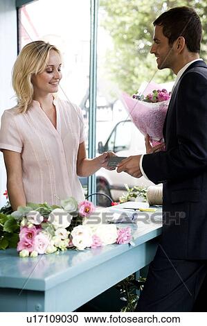 Man in a florist's shop, buying a bouquet of flowers View Large Photo Image Stock Image - Man in a florist's shop, buying a bouquet of flowers. Fotosearch