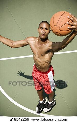 Man jumping and shooting on an outdoor basketball court View Large Photo Image Stock Photo - Man jumping and shooting on an outdoor basketball court . Fotosearch