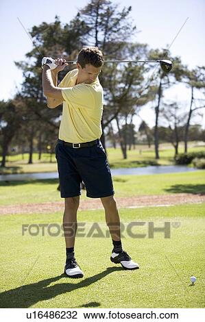 Stock Image - Man playing golf, teeing off. Fotosearch
