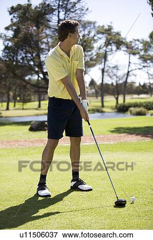 Stock Photo - Man playing golf, teeing off. Fotosearch