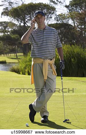 Man talking on a mobile phone on the golf course View Large Photo Image Stock Photo - Man talking on a mobile phone on the golf course. Fotosearch