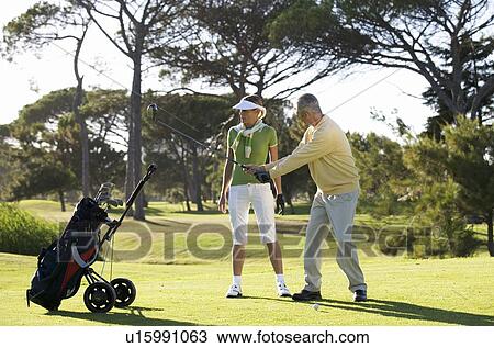 Man teaching a woman how to play golf View Large Photo Image Stock Image - Man teaching a woman how to play golf. Fotosearch
