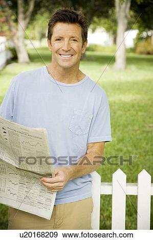 man with newspaper standing in the garden View Large Photo Image Stock Photo - man with newspaper standing in the garden. Fotosearch