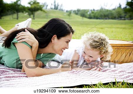 Stock Photo - mother and daughter lying on picnic rug. Fotosearch