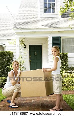 Stock Photo - Mother and daughter moving into their new home. Fotosearch